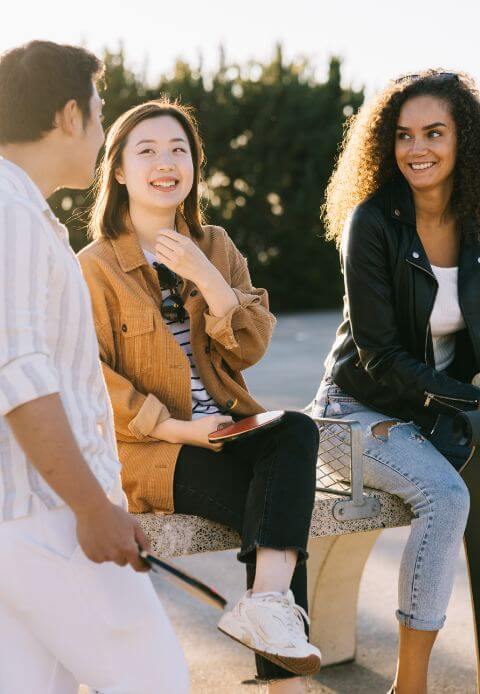 Image of people sitting on a bench in a park